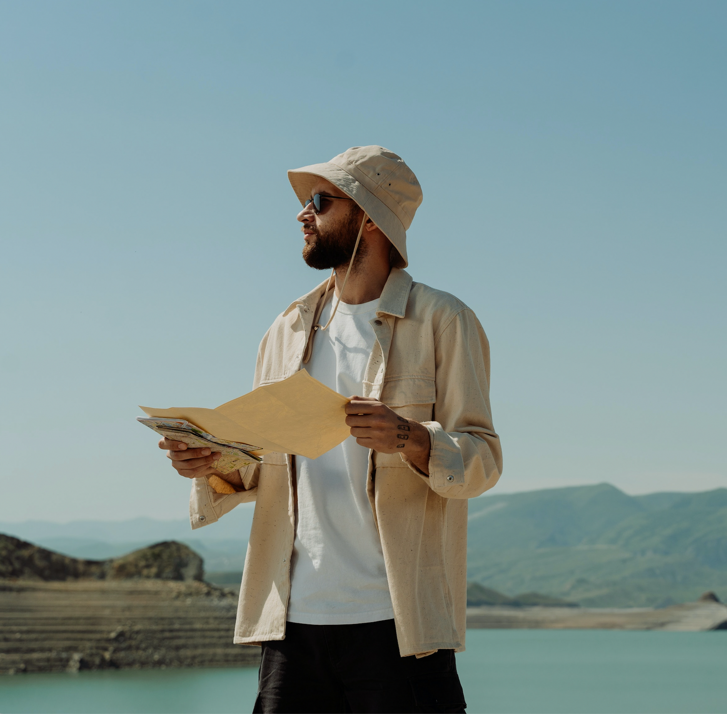 Man wearing a bucket hat holding a map