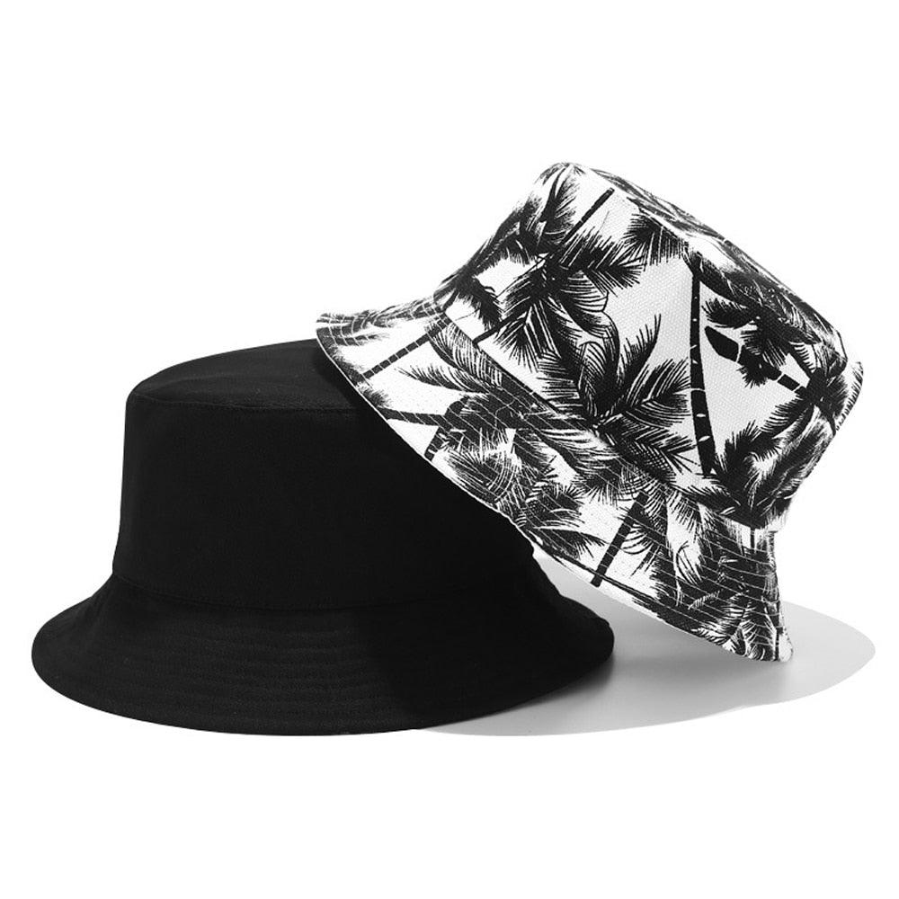 Reversible bucket hat with black and white coconut trees on it.
